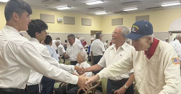 OCAPEX students shaking hands with veterans at a community visit