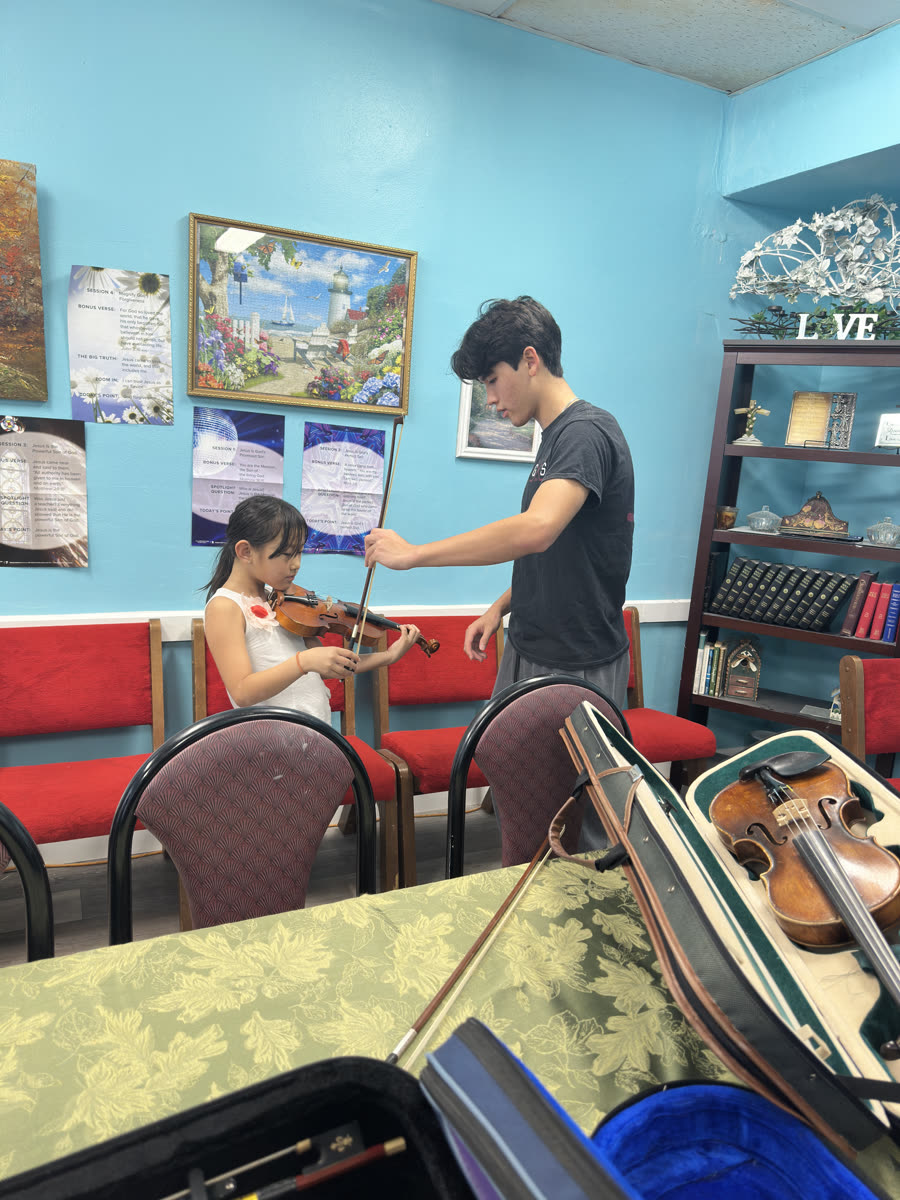 An OCAPEX mentor working one-on-one with a young violinist
