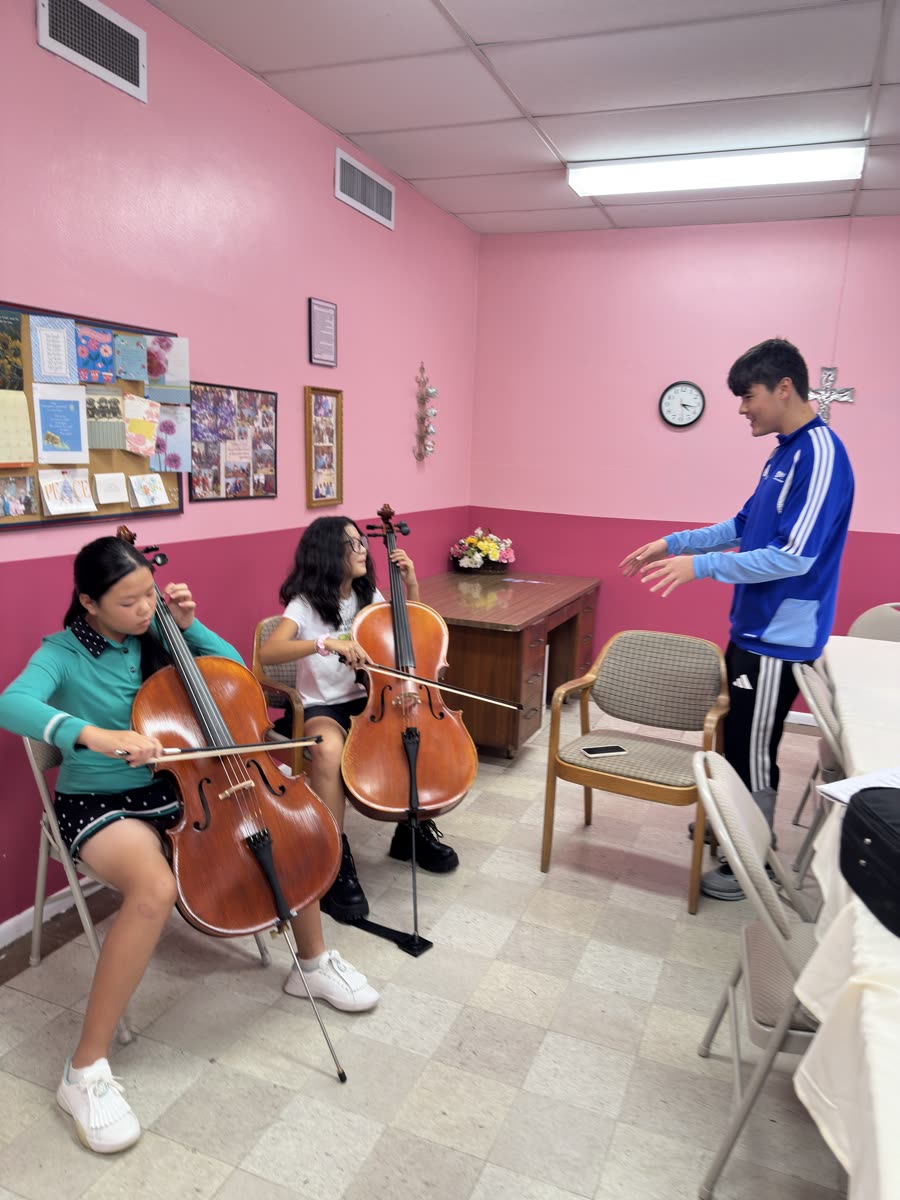 An OCAPEX mentor leading two young cellists through a passage