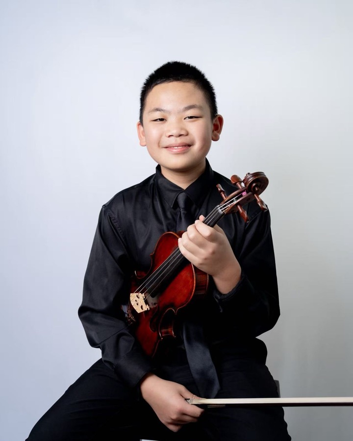Andrew Chen holding a violin